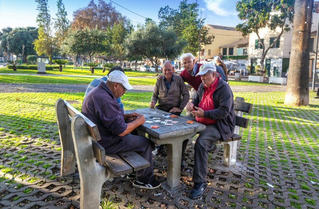 Seniors playing cards at a park table